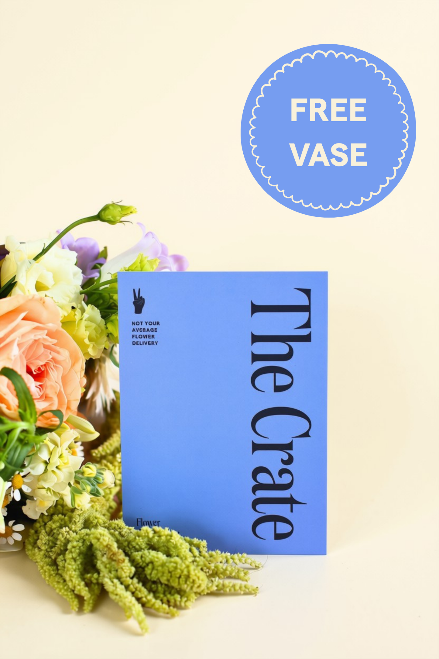 A blue flower subscription card "The Crate" stands upright on a cream background, styled with flowers at the left edge and a blue circular badge reading "FREE VASE" in the upper right.