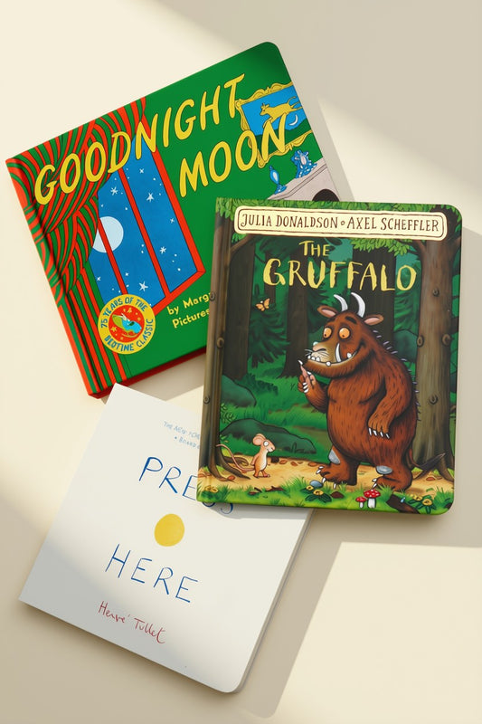 Three children's books arranged on a light beige surface: Goodnight Moon, The Gruffalo, and Press Here by Hervé Tullet.